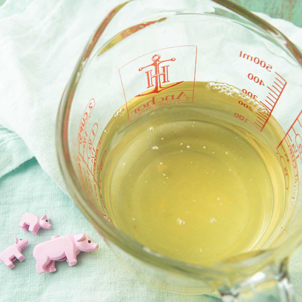 liquid lard in measuring cup and lego Pigs