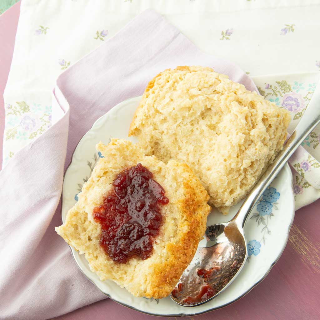 biscuit spread with jam on plate with spoon