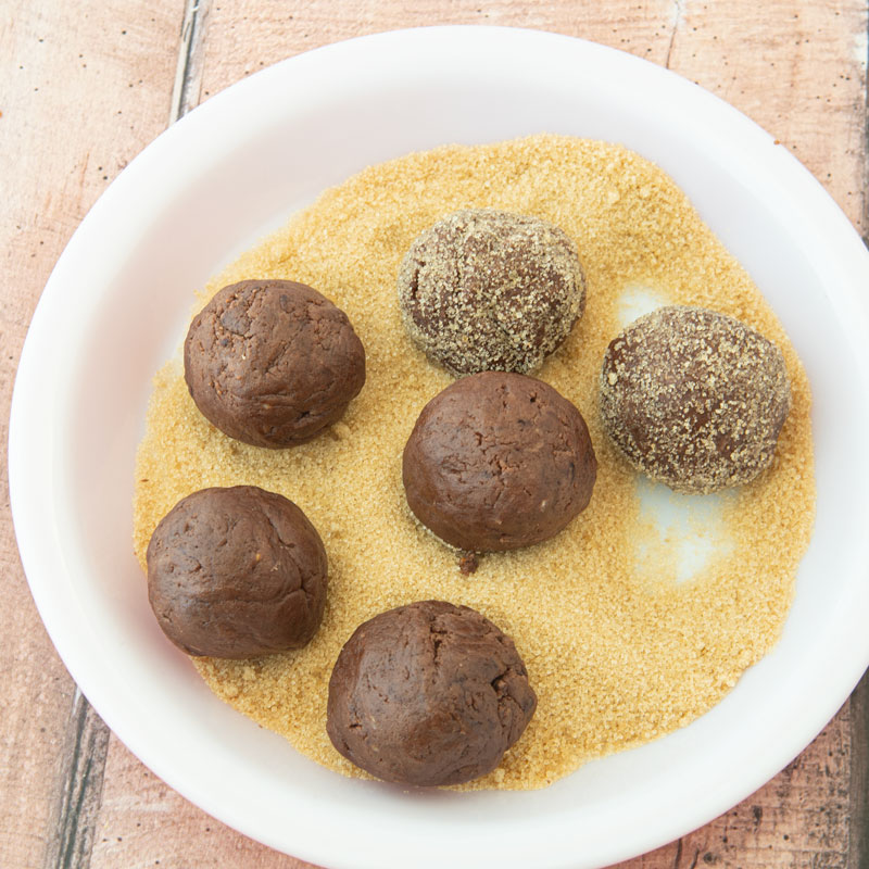 rolling chocolate dough in raw sugar