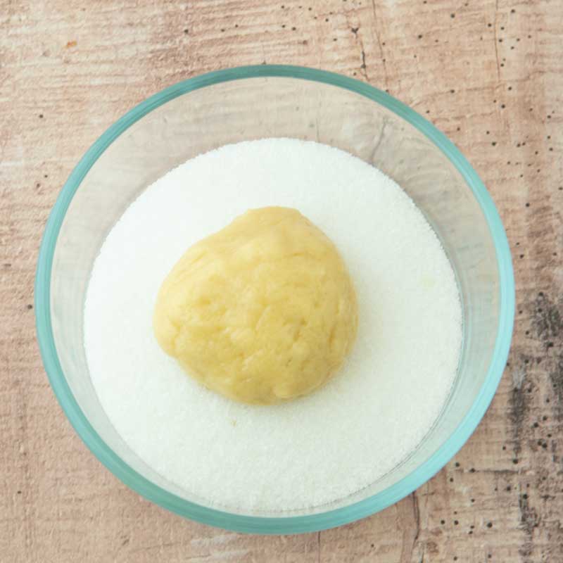 rolling cookie dough in sugar