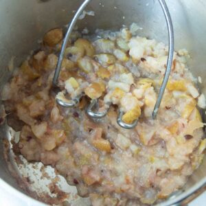 mashing pears with potato masher