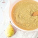 pear sauce in bowl next to whole pear