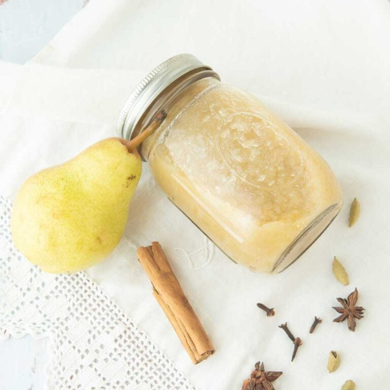 pear sauce in jar next to spices and whole pear
