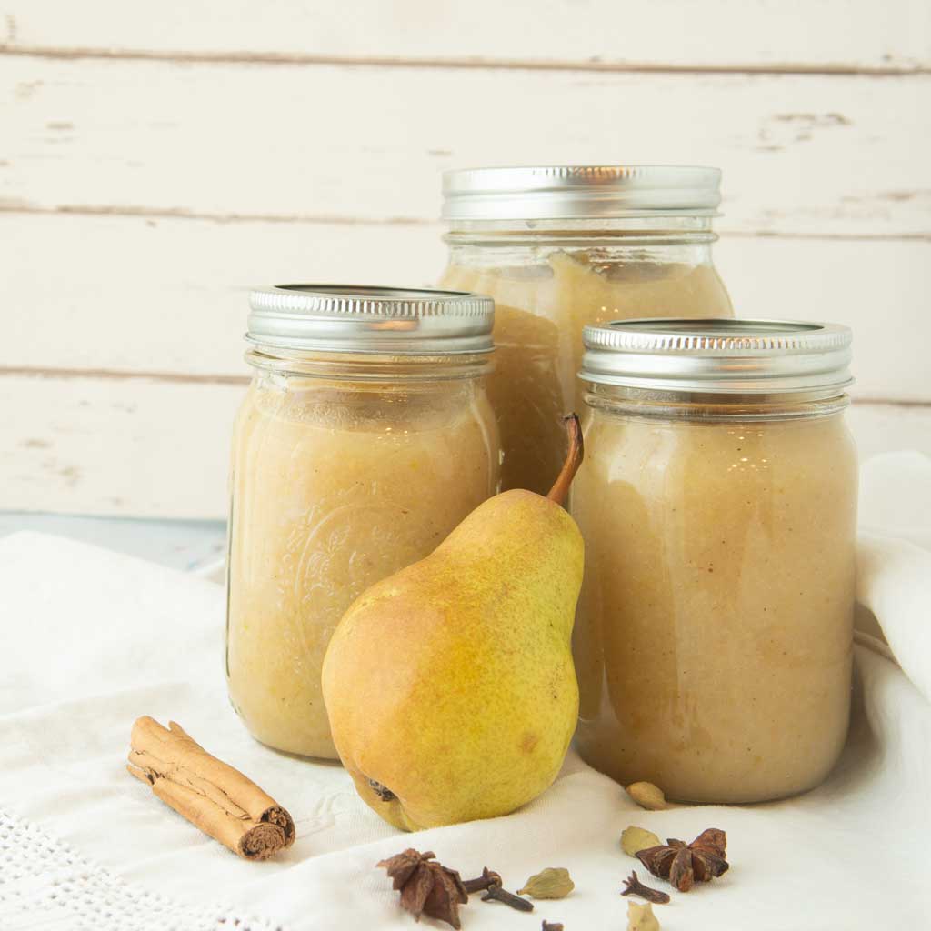 pear butter in jars with whole pear and spices