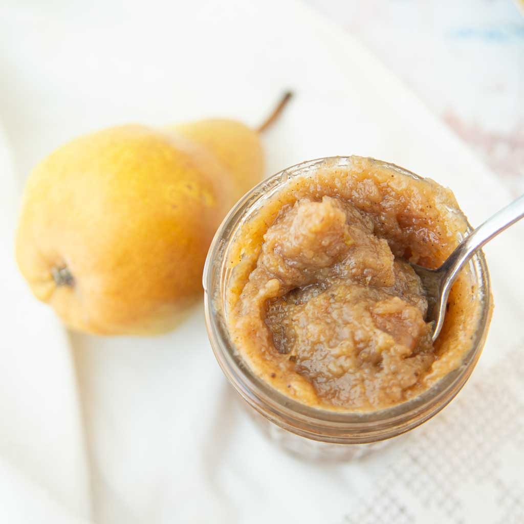 pear butter in jar with whole pear