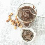 homemade nutella in jar with whole hazelnuts and chopped chocolate