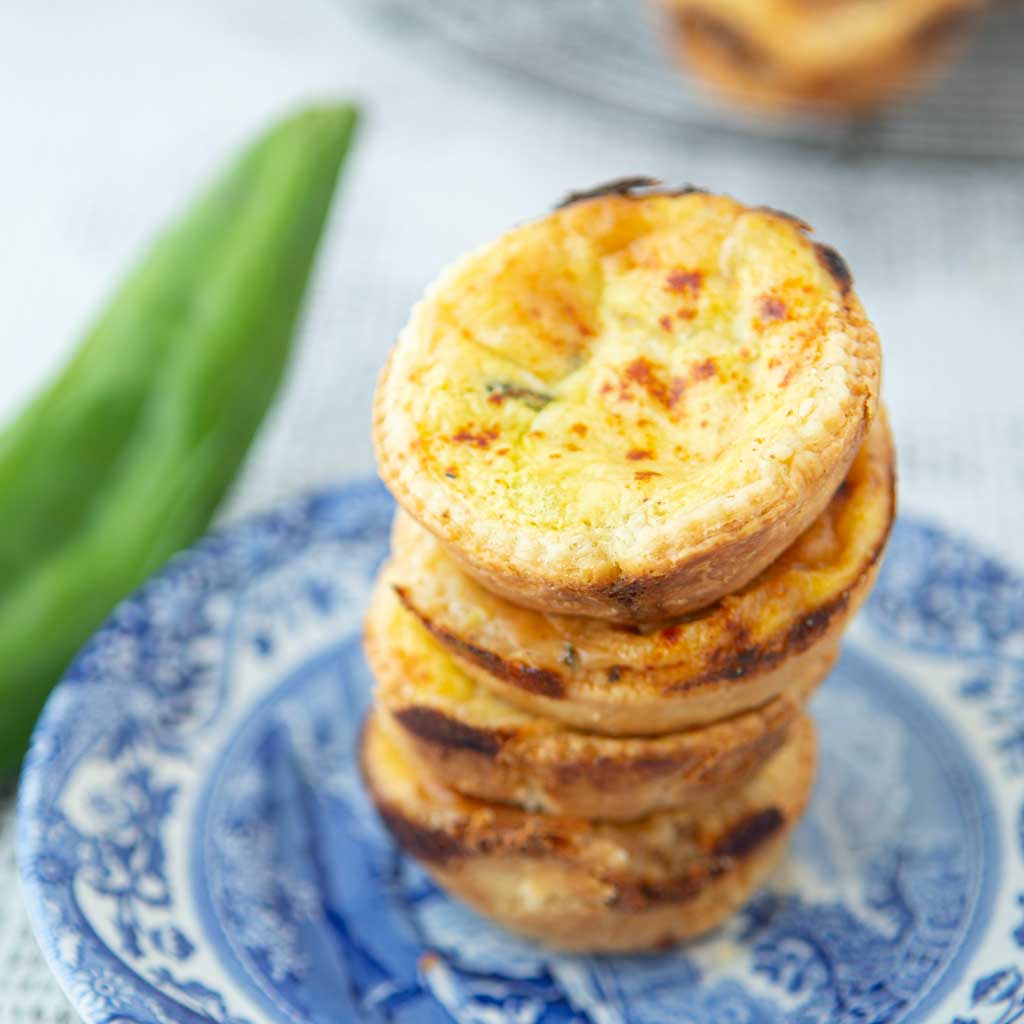 whole green chile and closeup of green chile mini quiches on plate