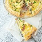 slice of bacon spinach quiche and pie plate of quiche