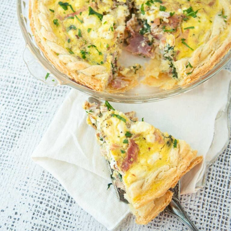 slice of bacon spinach quiche and pie plate of quiche