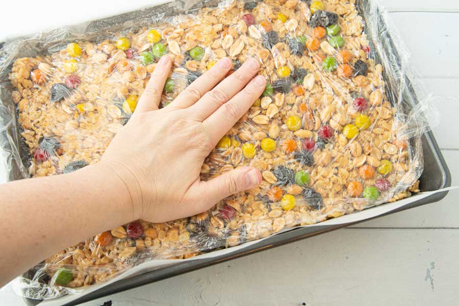 pressing trail mix into the top of cereal bars