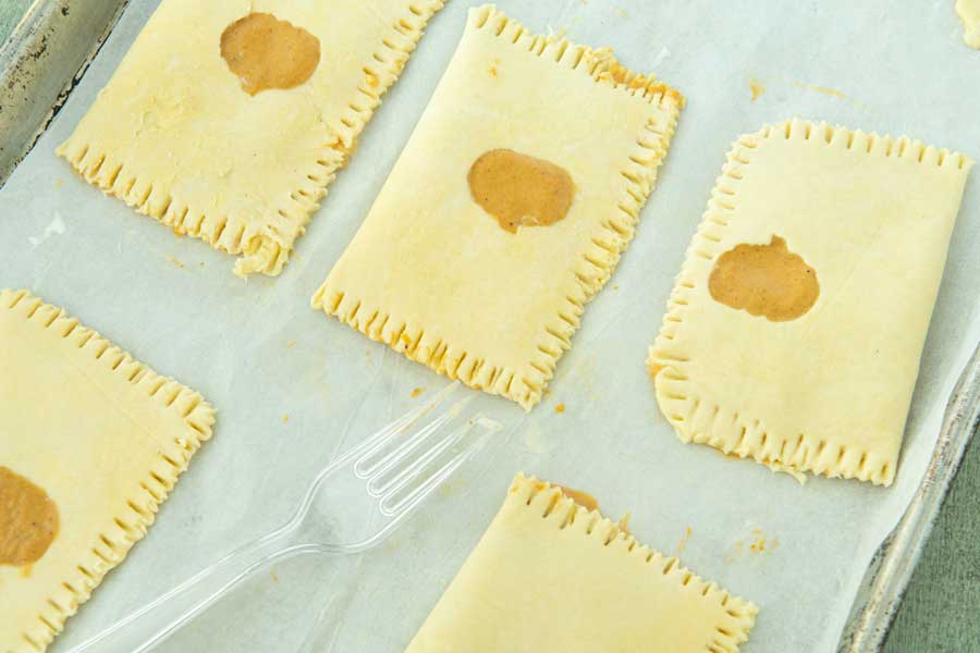 sealing edges of pumpkin hand pies with fork
