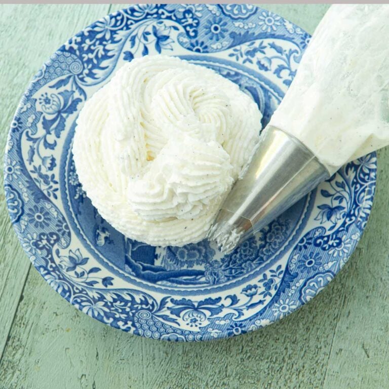 whipped cream frosting on plate next to piping bag