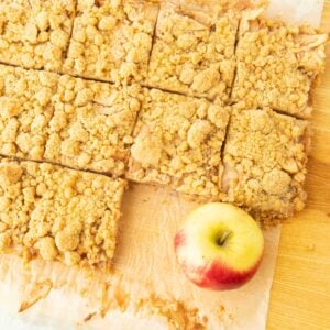 apple crumble bars on cutting board with whole apple