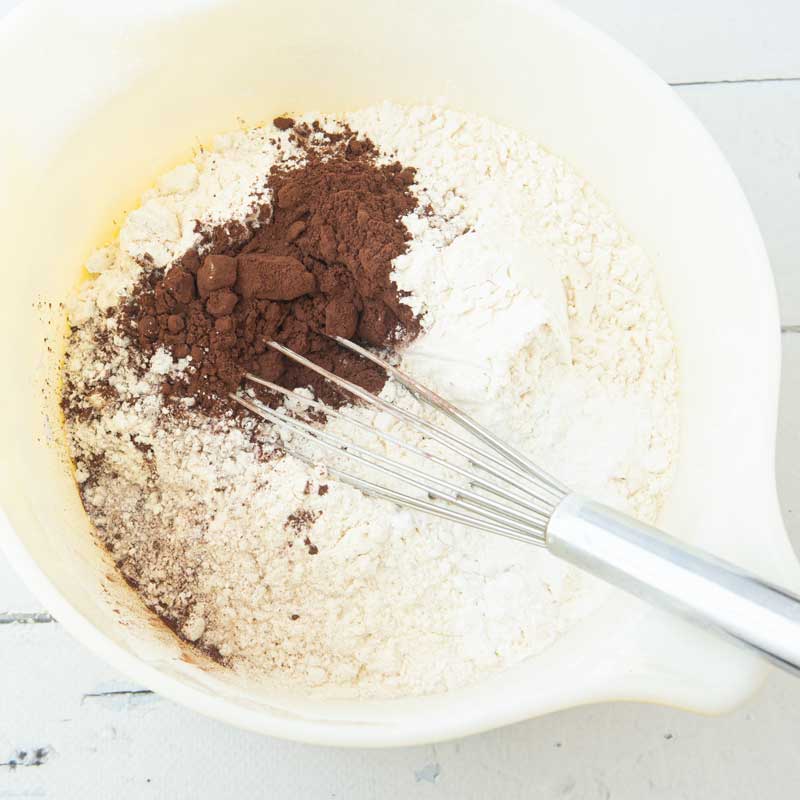 whisking cocoa into flour