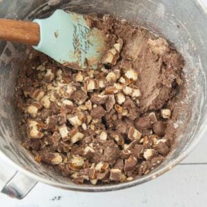 folding chopped Twix into chocolate cookie dough