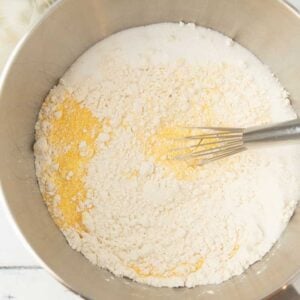 mixing flour and cornmeal with whisk in bowl