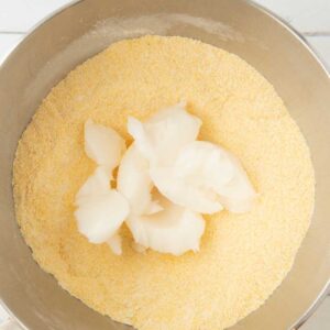 adding lard to cornmeal in bowl