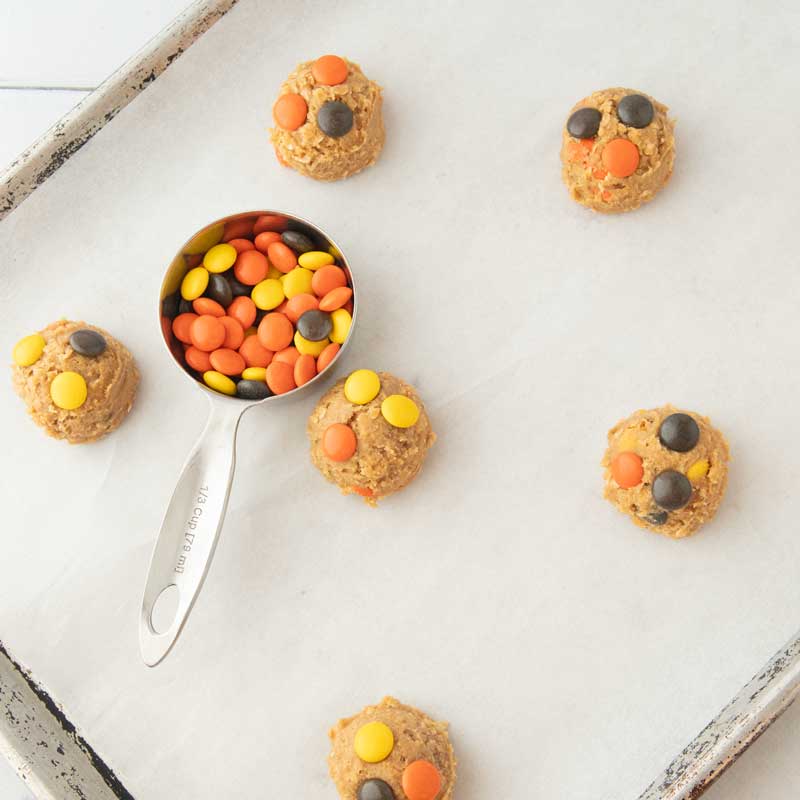 placing reese's pieces on cookie dough balls