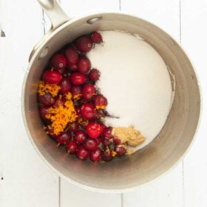 sugar, cranberries, ginger, and orange zest in pot