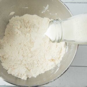 adding milk to puff pastry dough