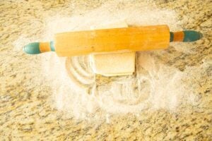 rolling puff pastry dough on sugar