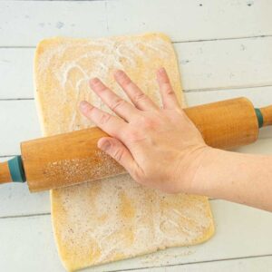 pressing sugar into puff pastry dough