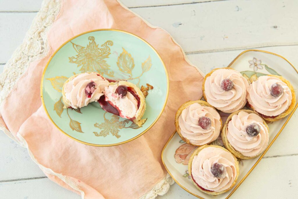 cranberry tart on plate cut open and larger plate of cranberry tarts