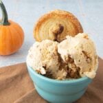 pumpkin ice cream in cup with palmier and whole pumpkin in background