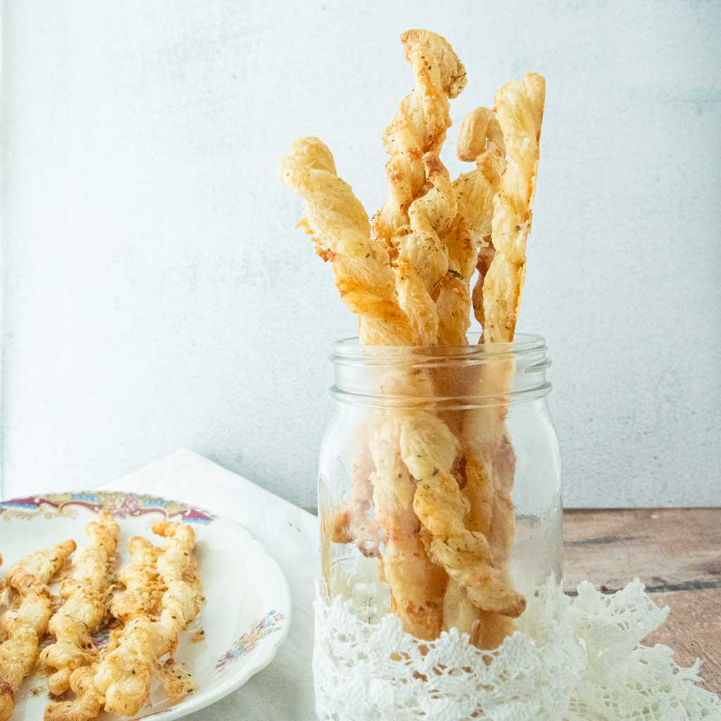 puff pastry cheese straws on plate and in glass