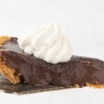 slice of chocolate pie on pie server with whipped cream