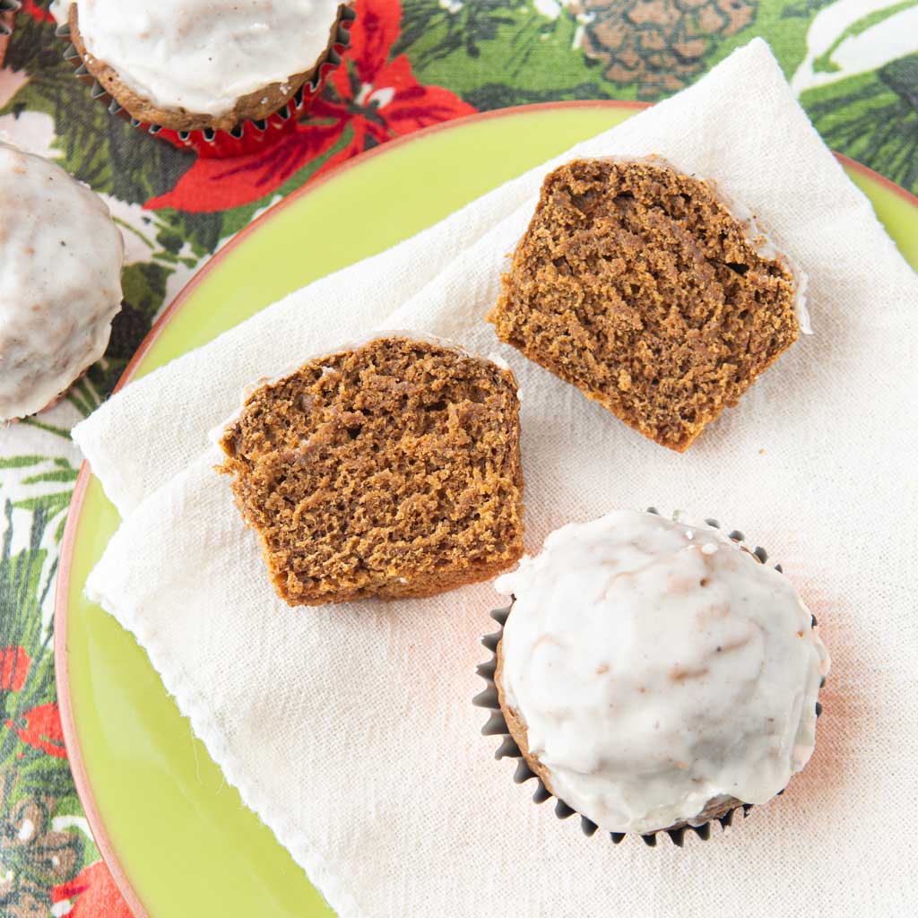 sliced gingerbread muffin on plate with whole gingerbread muffins