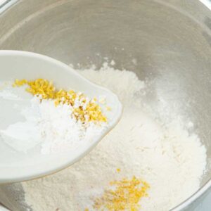 adding lemon zest and baking powder to flour