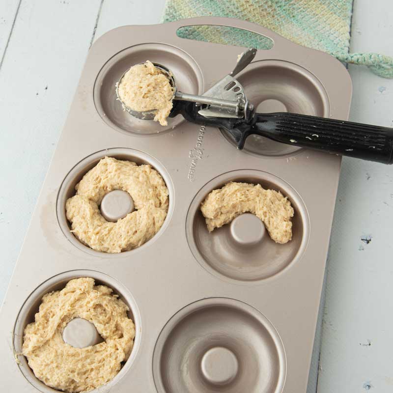 adding batter to donut pan