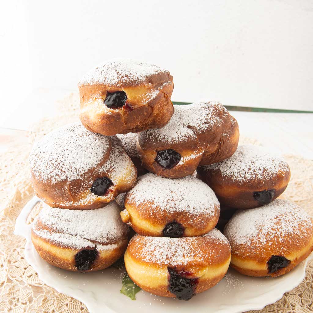 stack of jam filled paczki on plate