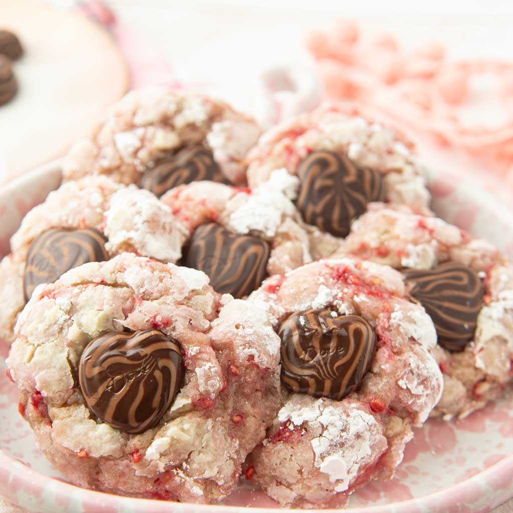 closeup of raspberry cookies on plate with chocolate heart centers