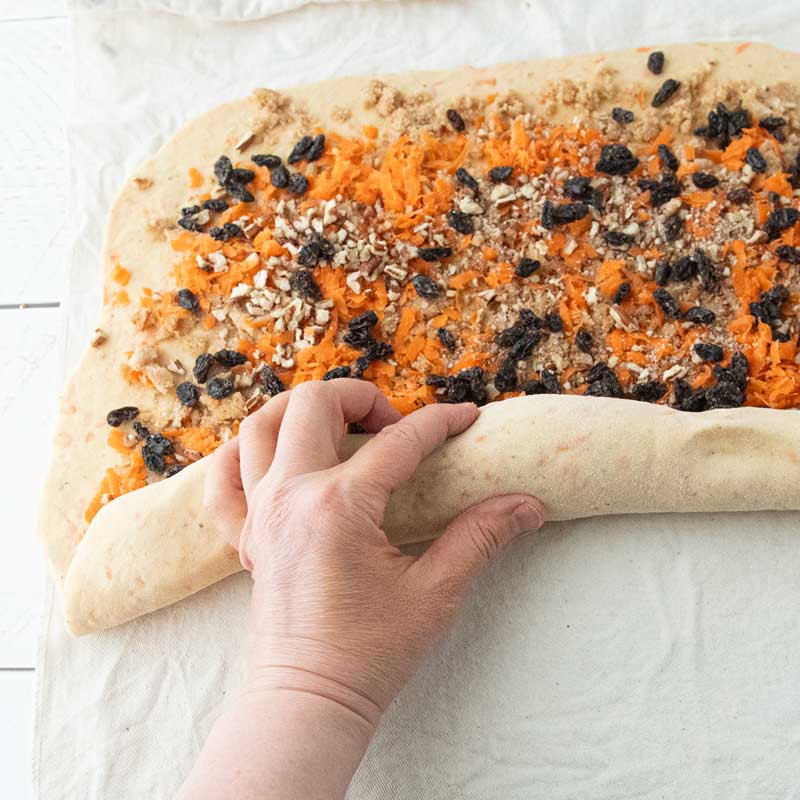 rolling dough over carrot cake filling