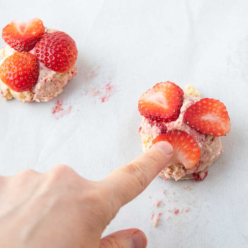 pressing strawberry slices on cookie tops