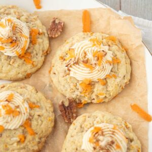 closeup of carrot cake cookies on plate with pecans and carrot shreds