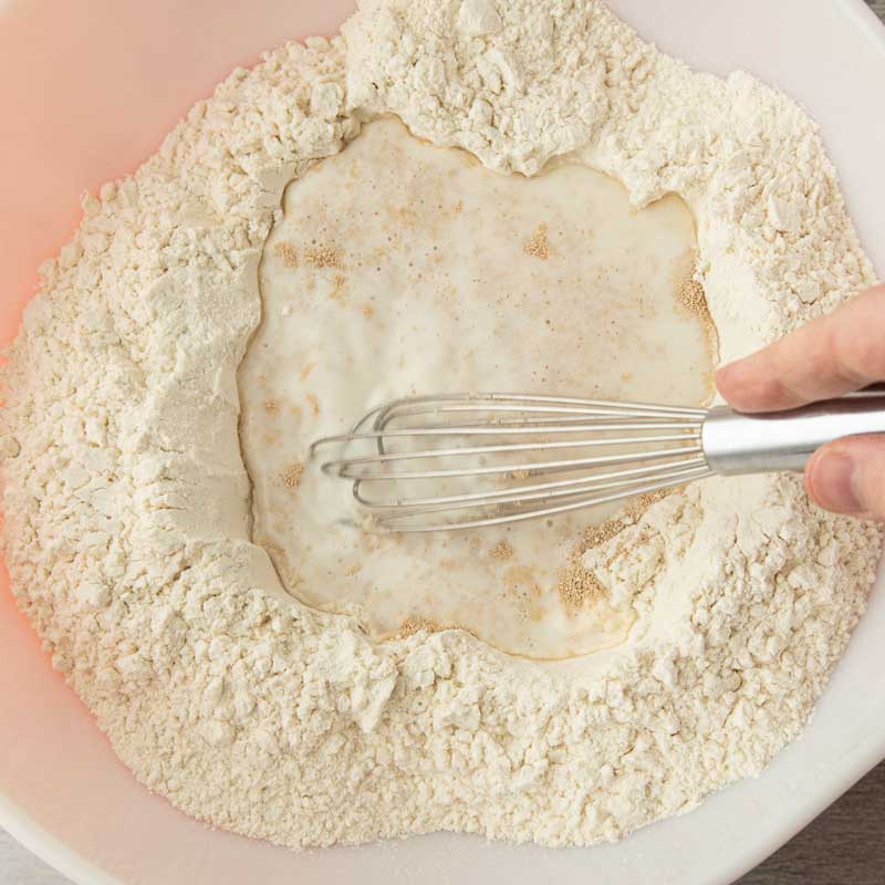 mixing yeast water in a bowl of flour