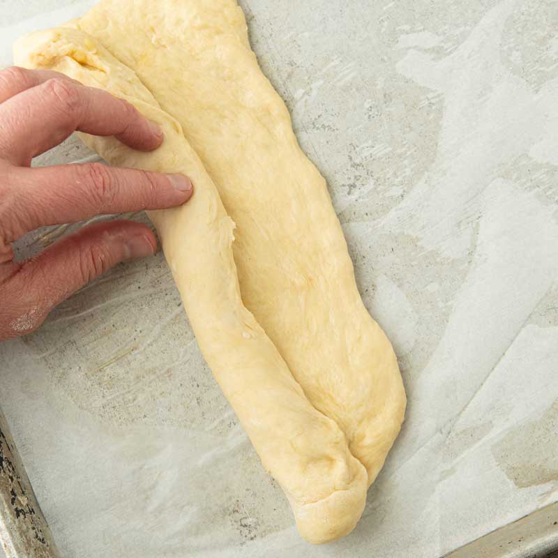 rolling dough to form a hoagie bun