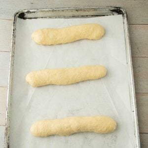 shaped hoagie buns on sheet tray
