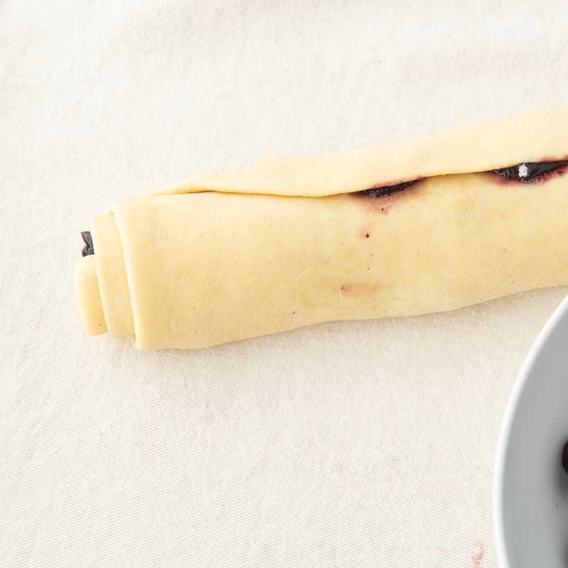 roll of lemon blueberry dough ready to cut into rolls