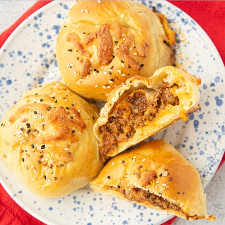 baked sloppy joe buns on plate with cross section of buns