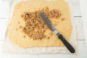 spreading brown sugar on dough