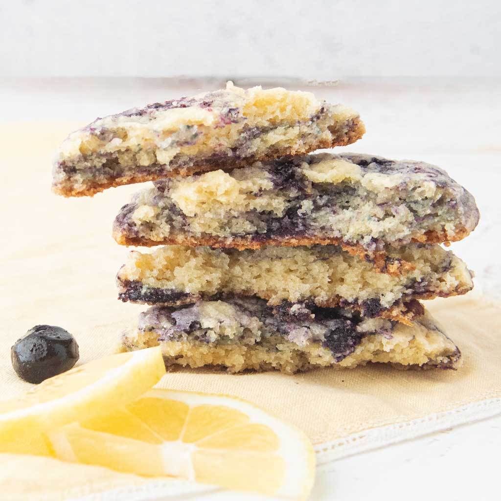 cross-section stack of lemon blueberry cookies next to lemon slices and blueberries