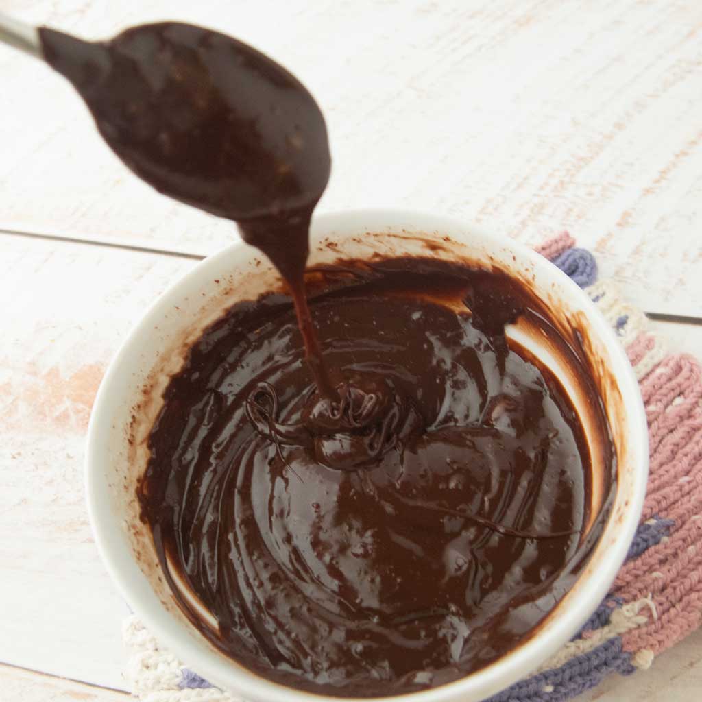 dripping ganache into bowl from spoon