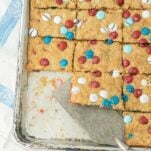 cut bars of m&m oatmeal cookie bars with pie server