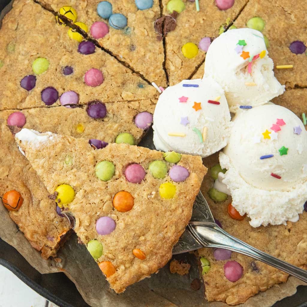 oatmeal skillet cookie and ice cream scoops with slice of cookie on pie server