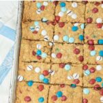 cut bars of m&m oatmeal cookie bars with pie server, text overlay
