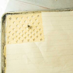 stripes drawn on parchment next to stars cut on pastry dough